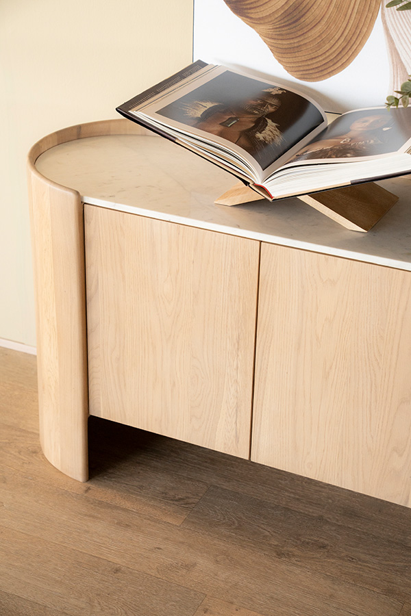 Licht eiken dressoir met ronde uiteinden, greeploze deuren en wit marmeren blad.